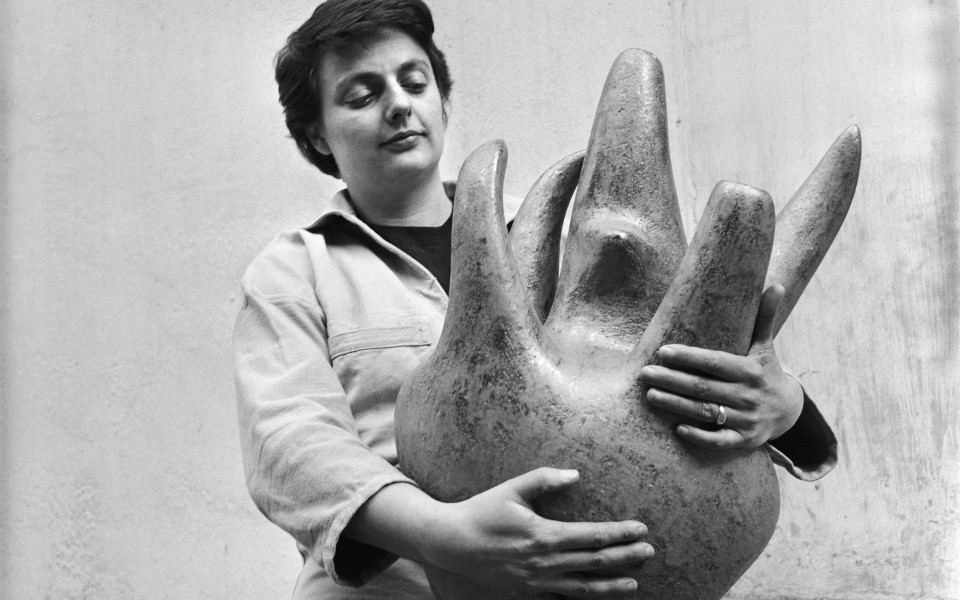 Photo en noir & blanc de Valentine Schlegel tenant dans ses deux bras une de ses sculptures-vases