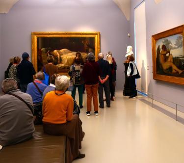 Un groupe de visiteurs regarde un tableau dans une salle du musée